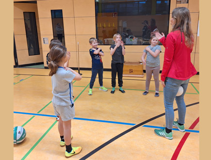 Trainer zeigt Schüler Übungen Handball